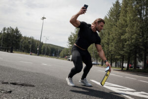 A man throwing phones in the asphalt